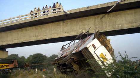 Indian police officers look down from a bridge at the wreckage of a bus after an accident in Sawai Madhopur district, nearly 185 kilometres west of Jaipur, India, Monday, March 15, 2010. (AP / Rajasthan Patrika)